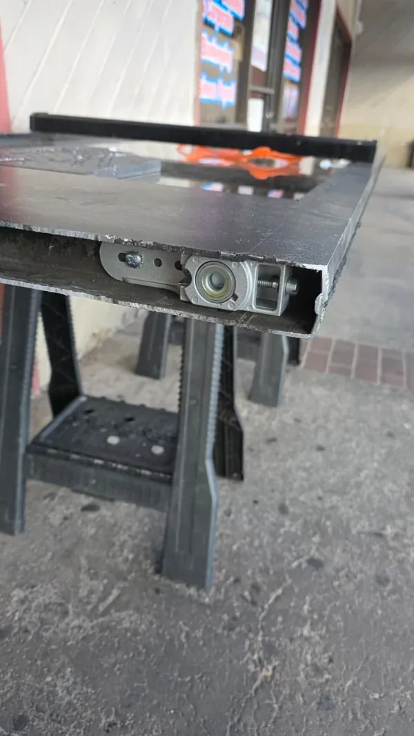 Close-up of hardware at the lower rail of the glass door