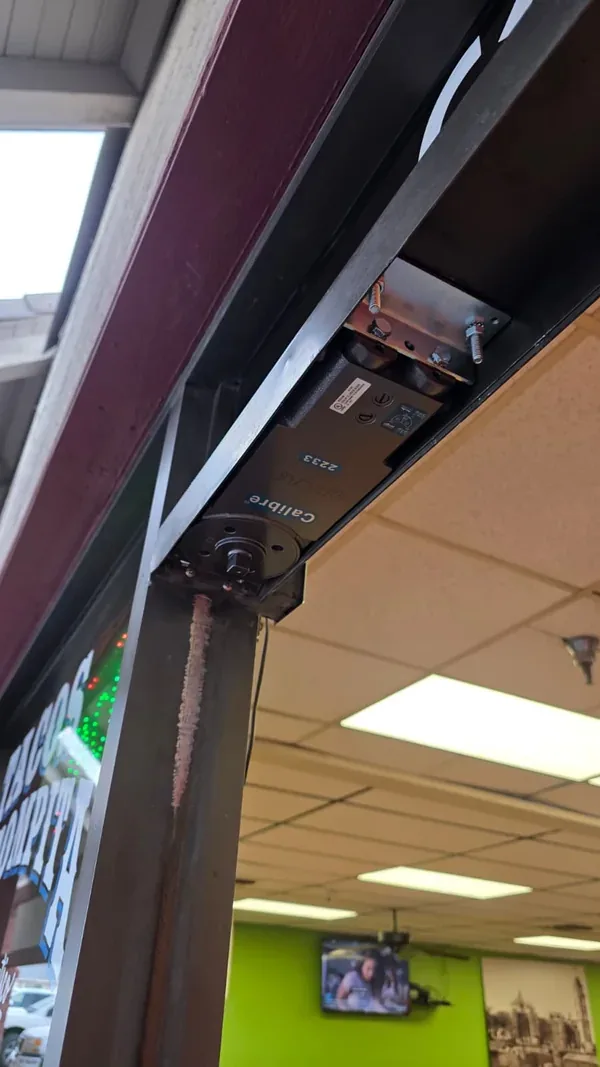 Exposed concealed door closer inside the commercial entrance header